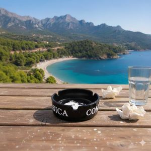 Cendrier Corsica en verre noir motif Tête de Maure posé sur une table en bois