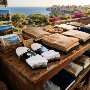 Lot de 3 paires de chaussettes Corsica , blanche, grise et noires sur une etagere vue sur la mer Corse