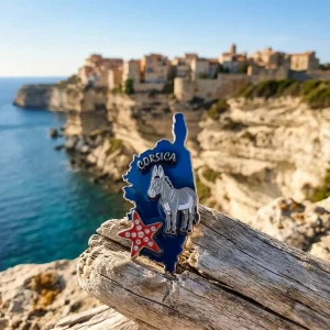 Magnet en métal émaillé U Sumerinu en forme de carte de Corse avec un âne gris et une étoile de mer brillante à strass.