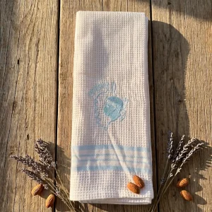 Torchons nid d'abeille corse Mare et Monti brodés Corsica et Tête de Maure sur une table